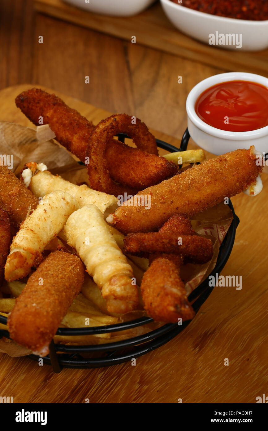 Mixed appetizer of french fries, fried sasusage, fried zucchini, pastry