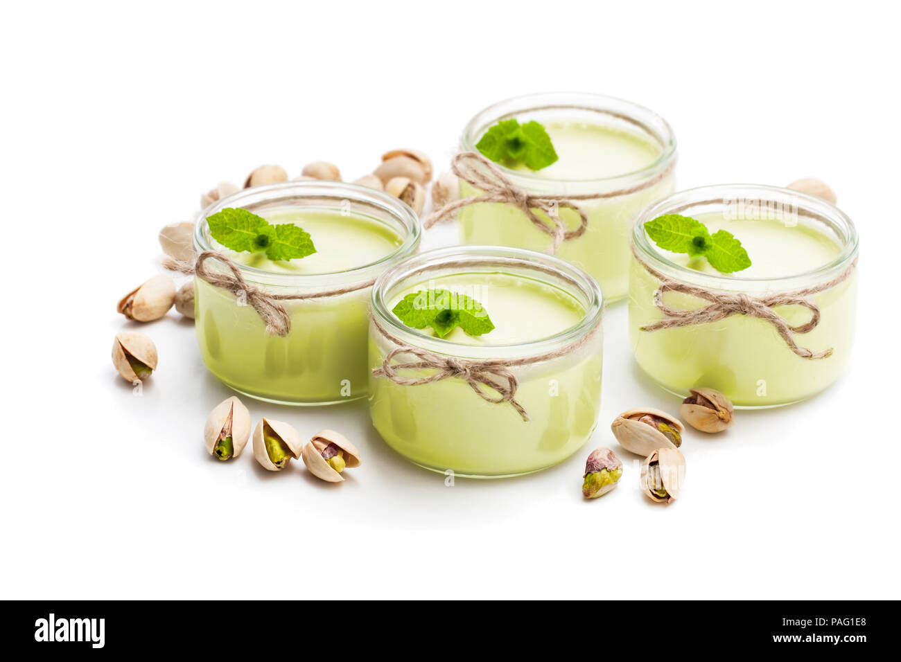 Natural pistachio yogurt in a small glass jar isolated on white Stock
