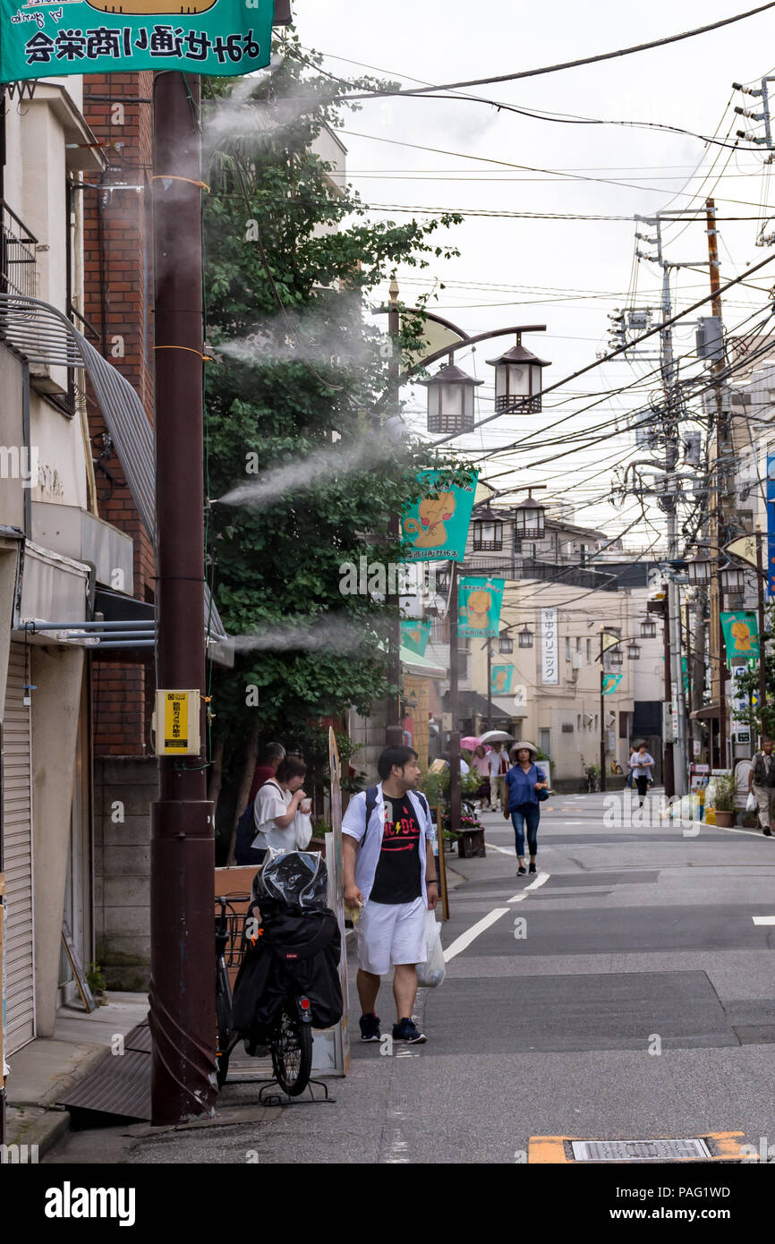 Combating the heatwave in Tokyo street scene in summer rain by spraying fine mist of cool water into the air Stock Photo