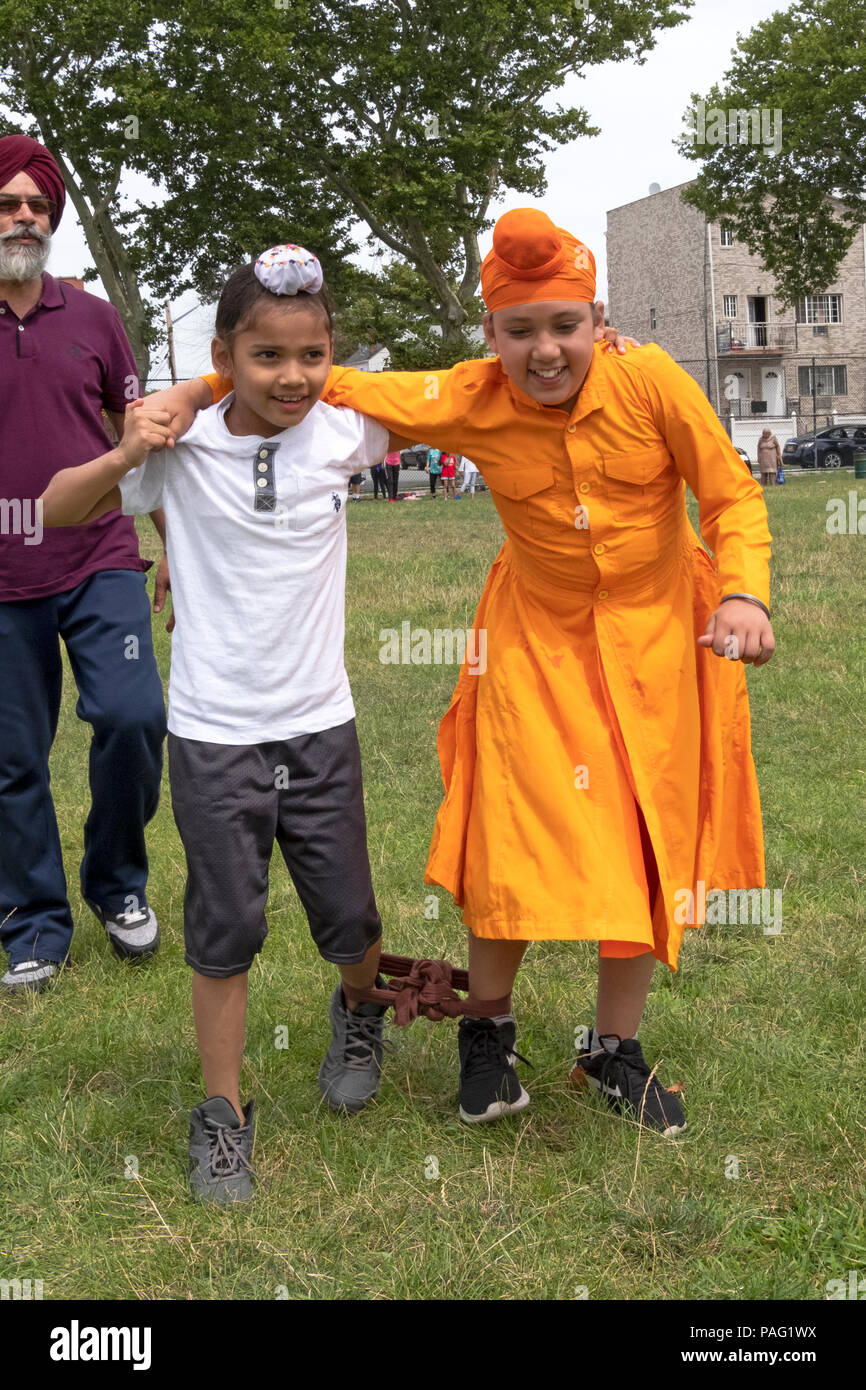 Two young boys boys competing in a three legged race at the Sikh Gurmat