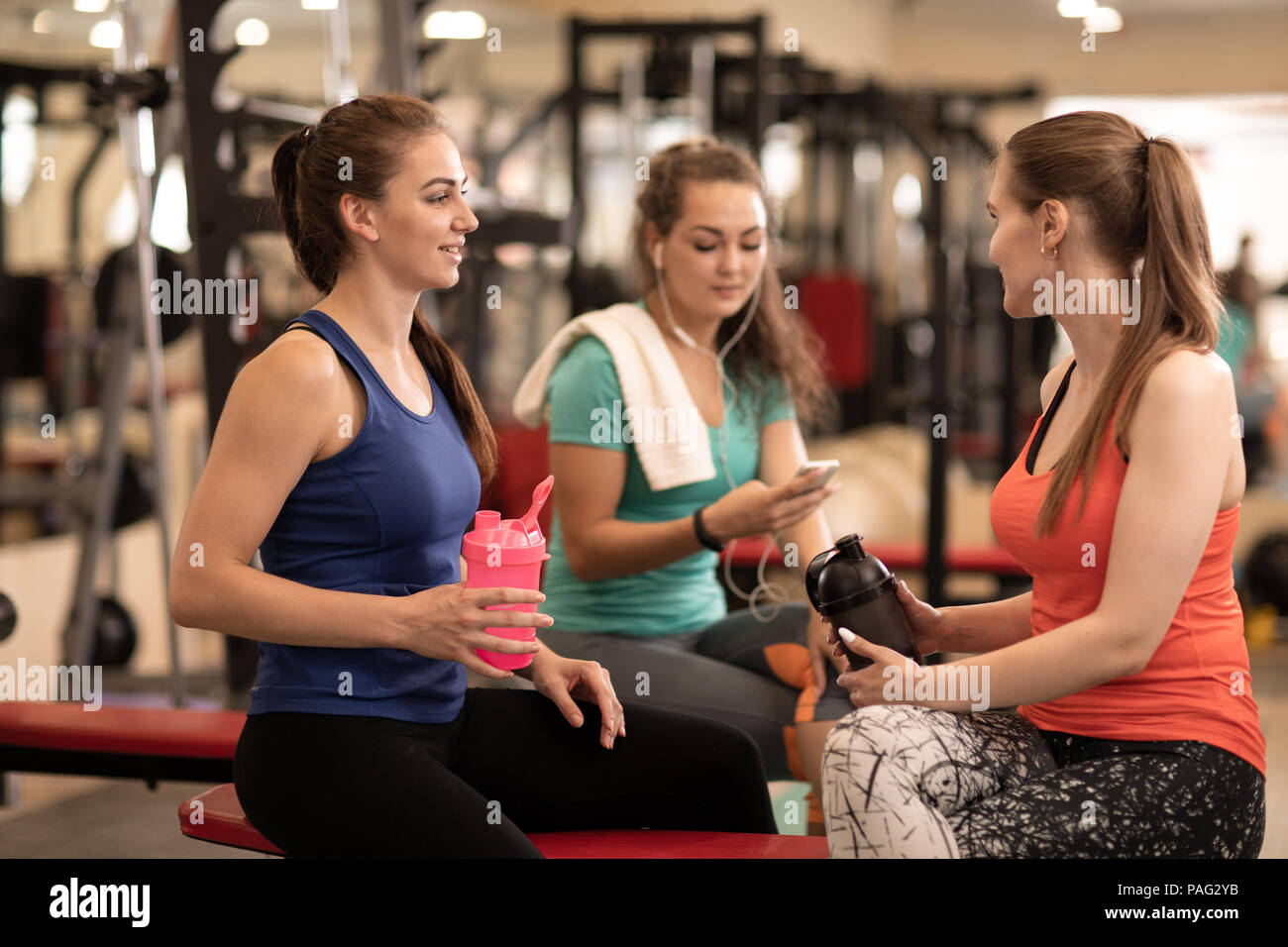 Happy young women resting after fitness training in gym Stock Photo