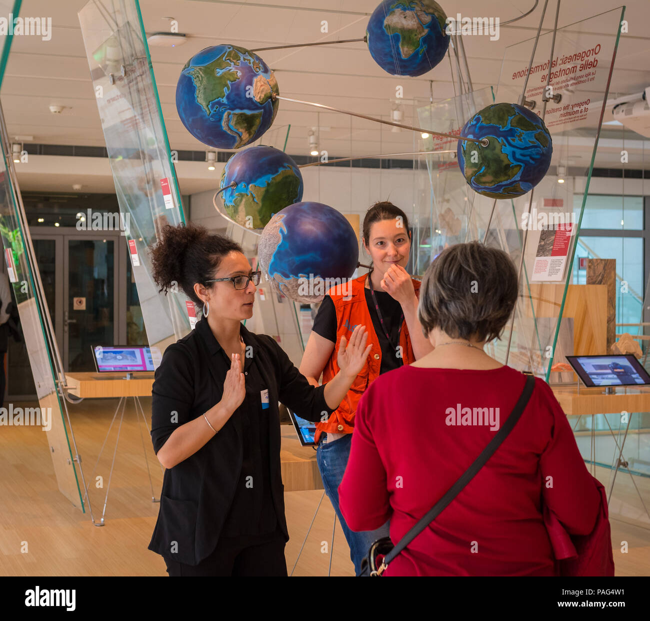 Guide of the museum speaks with sign language to deaf users in the Science Museum of Trento  - MuSe -Trentino Alto Adige, Italy. Stock Photo