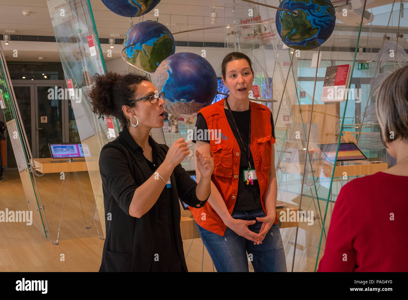 Guide of the museum speaks with sign language to deaf users in the Science Museum of Trento  - MuSe -Trentino Alto Adige, Italy. Stock Photo