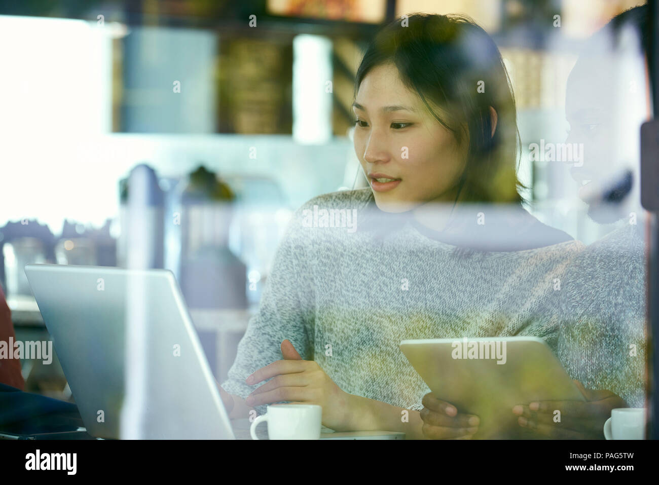 Young friends using laptop and digital tablet Stock Photo