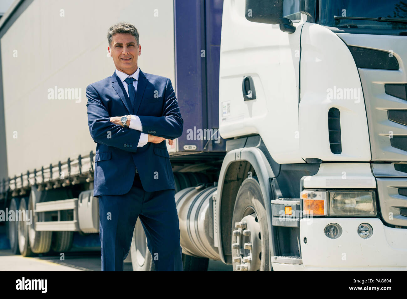 Businessman standing in front of lorry Stock Photo