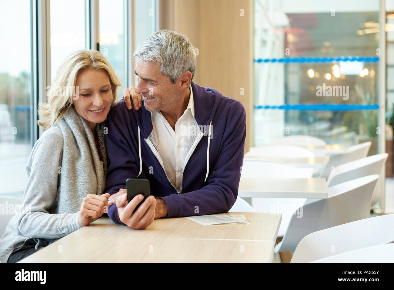 Couple using smart phone in cafŽ Stock Photo