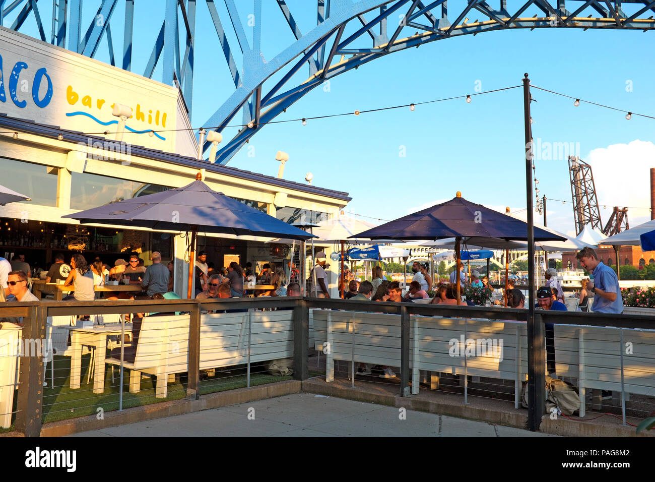 Summer outdoor dining and drinking at sunset at Coastal Taco in the Cleveland Flats entertainment district in Cleveland, Ohio, USA. Stock Photo