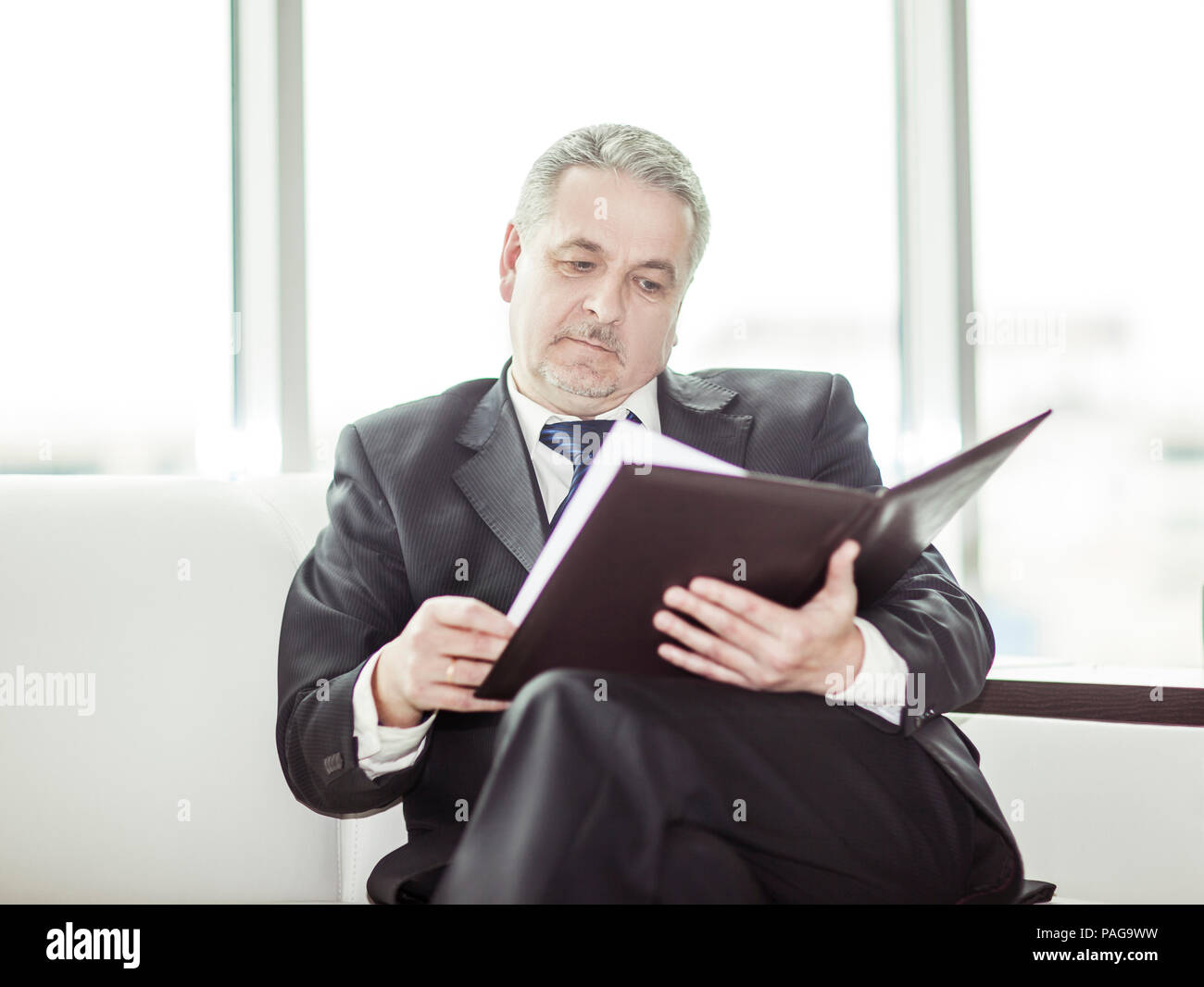 experienced lawyer reviews the documents with the terms of a new contract Stock Photo