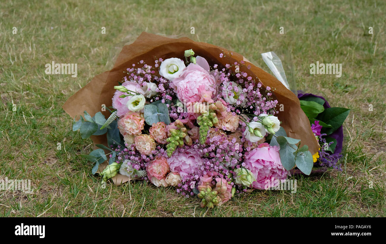 Big beautiful bouquet of flower in pink, purple, and white, with a grass background. Stock Photo