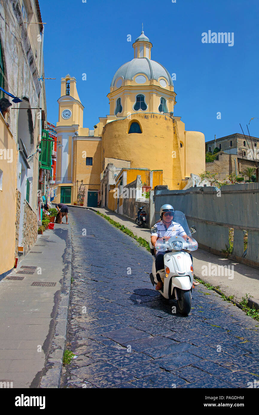 Motor scooter at a alley, church Chiesa della Madonna delle Grazie, old town of Procida, Gulf of Naples, Italy Stock Photo