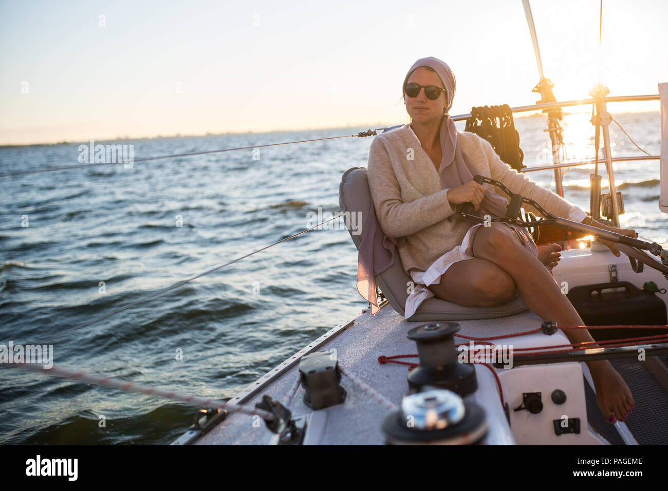 Young woman on a the helm on a sailboat Stock Photo