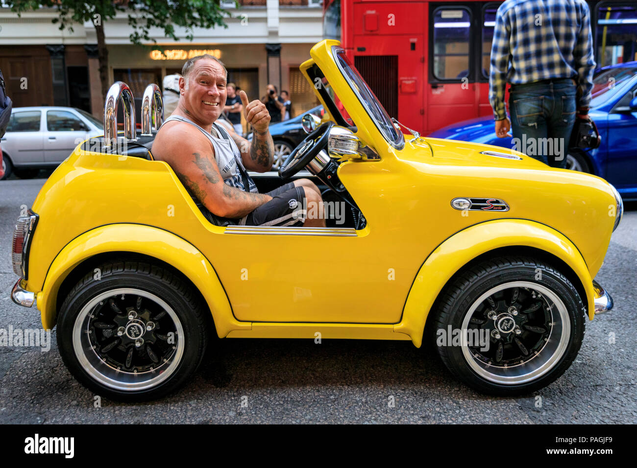 Sloane Street, London, UK, 20th July 2018. A 'cut-down' Mini in bright yellow, complete with smiling owner and a Mr. Bean on the dashboard, steals the show and is clearly popular. Supercars, high-performance and classic cars, as well as some characterful adaptions, line up and drive along Sloane Street for Supercar Sunday, which sees around 400 cars attending. The meetup is organised by Surrey Car Meet and on social media. Stock Photo