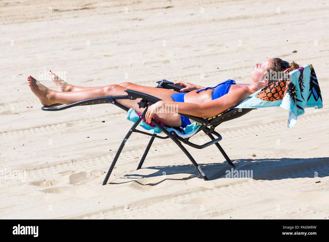 Bournemouth, Dorset, UK. 23rd July 2018. UK weather: the heatwave continues as temperatures rise on a scorching hot and sunny day at Bournemouth beaches with blue skies and unbroken sunshine. Sunseekers head to the seaside to soak up the sun. Woman sunbathing at the beach. Credit: Carolyn Jenkins/Alamy Live News Stock Photo
