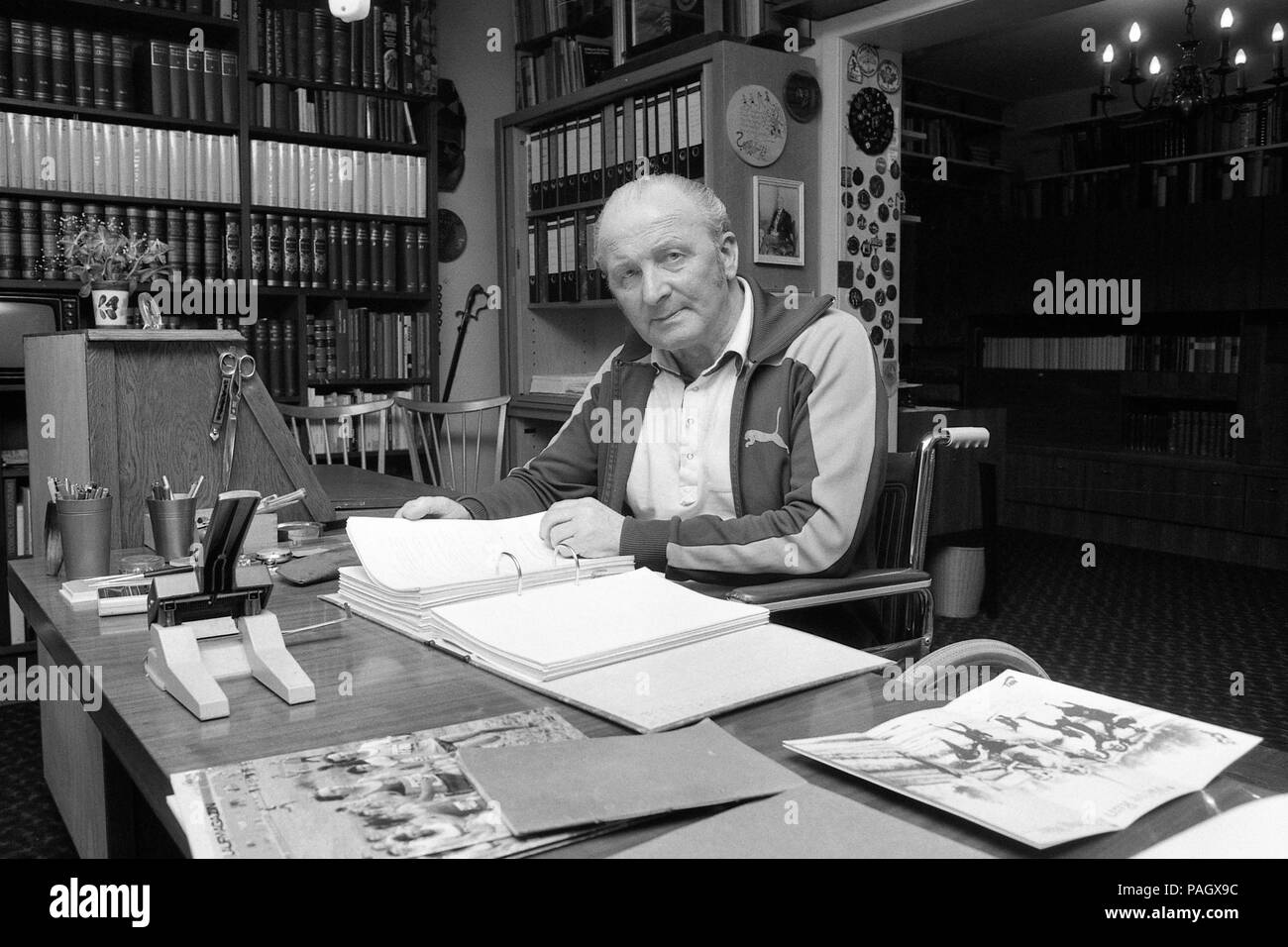 Dr. Ernst Van Aaken sports physician, running coach, private, civil, at home in his living room, sitting at a desk, pales in a file folder; In his apartment on 15.04.1980 in Waldniel (Schwalmtal)/Germany; Black and white recording; | usage worldwide Stock Photo