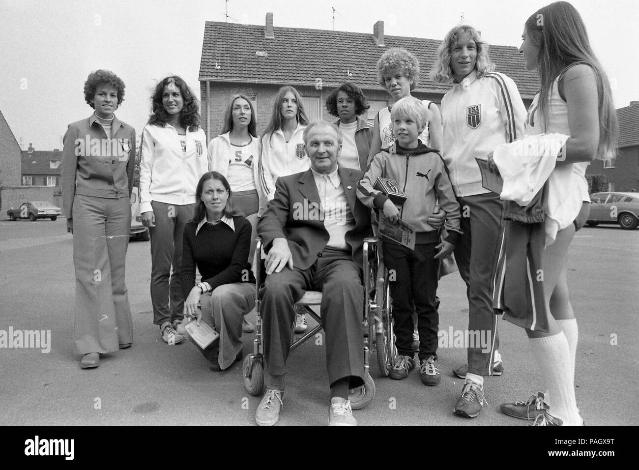 Dr. Ernst Van Aaken sports physician, running coach, sitting in a wheelchair, is surrounded by Laeuferinnen, sportswomen, marathon runners from the United States, who have come to a organized by him marathon in Waldniel; Women Marathon on 02.10.1976 in Waldniel (Schwalmtal)/Germany | usage worldwide Stock Photo