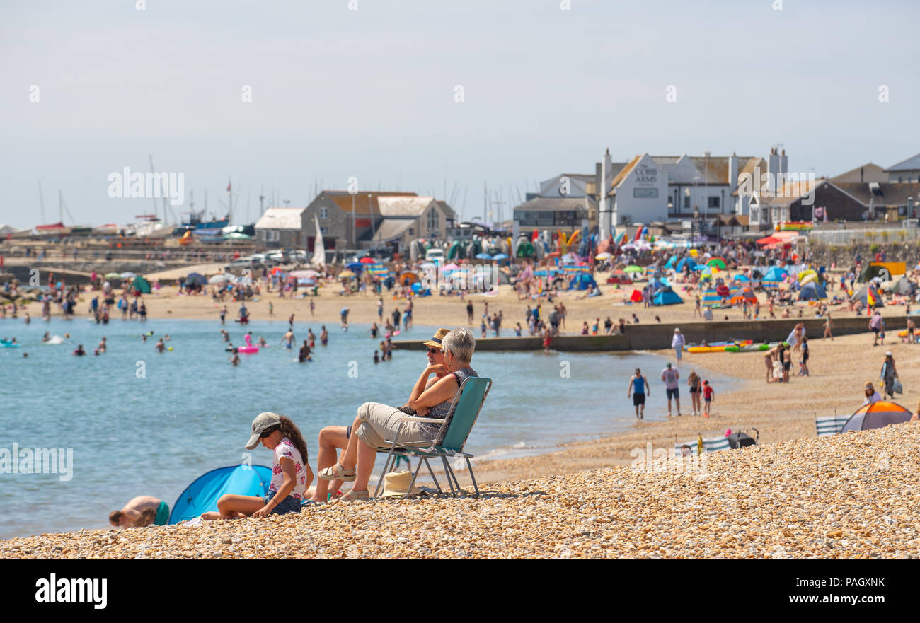 Lyme Regis, Dorset, UK. 23rd July 2018.  UK Weather: Another glorious start to the week in Lyme Regis with scorching hot sunshine and blue sky forecast again this week as the Spanish Plume is set to hit the UK with Mediterranean heat.  Crowds of sunbathers hit the pretty beach at the  seaside resort of Lyme Regis again today. Credit: Celia McMahon/Alamy Live News. Stock Photo