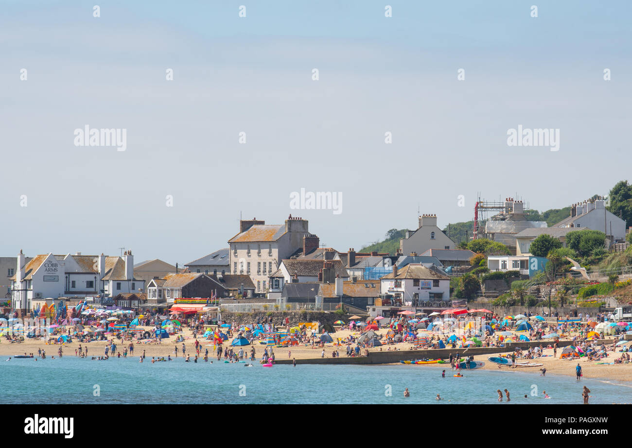 Lyme Regis, Dorset, UK. 23rd July 2018.  UK Weather: Another glorious start to the week in Lyme Regis with scorching hot sunshine and blue sky forecast again this week as the Spanish Plume is set to hit the UK with Mediterranean heat.  Crowds of sunbathers hit the pretty beach at the  seaside resort of Lyme Regis again today. Credit: Celia McMahon/Alamy Live News. Stock Photo