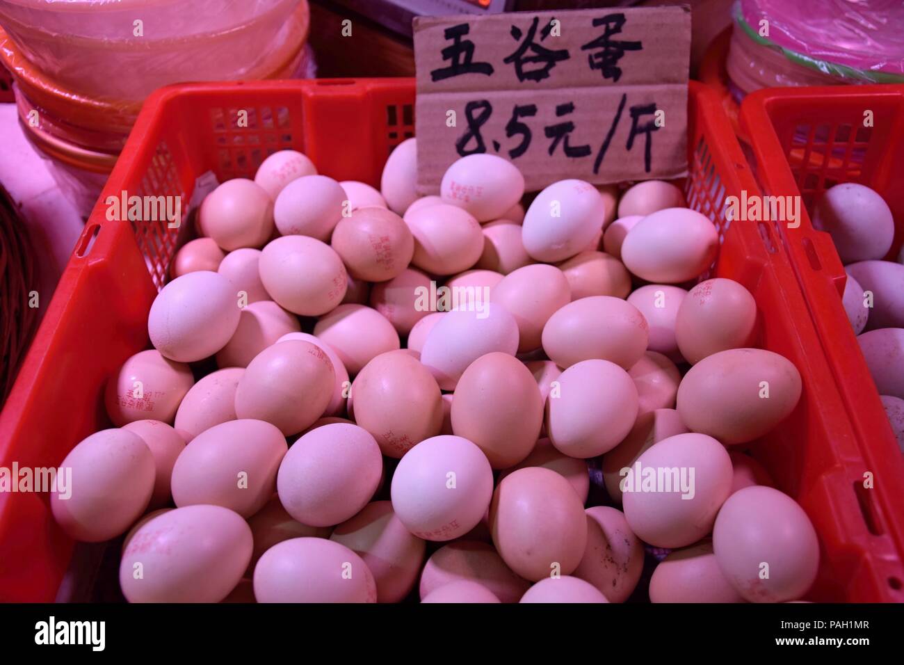 Fresh hen eggs heaped up inside the plastic basket. Translation "hen