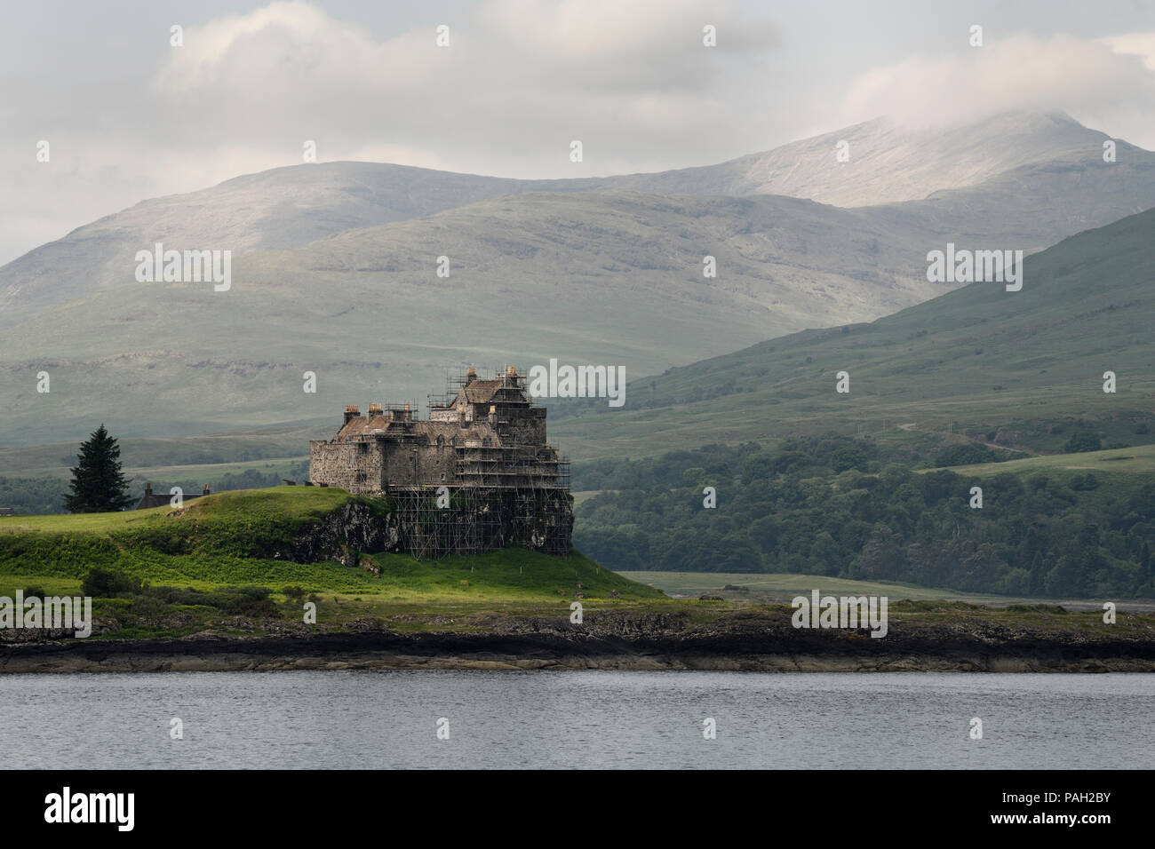 Scaffolding on Duart Castle on the Firth of Lorn Isle of Mull in west coast highlands and Dun da Ghaoithe mountain Scotland UK Stock Photo