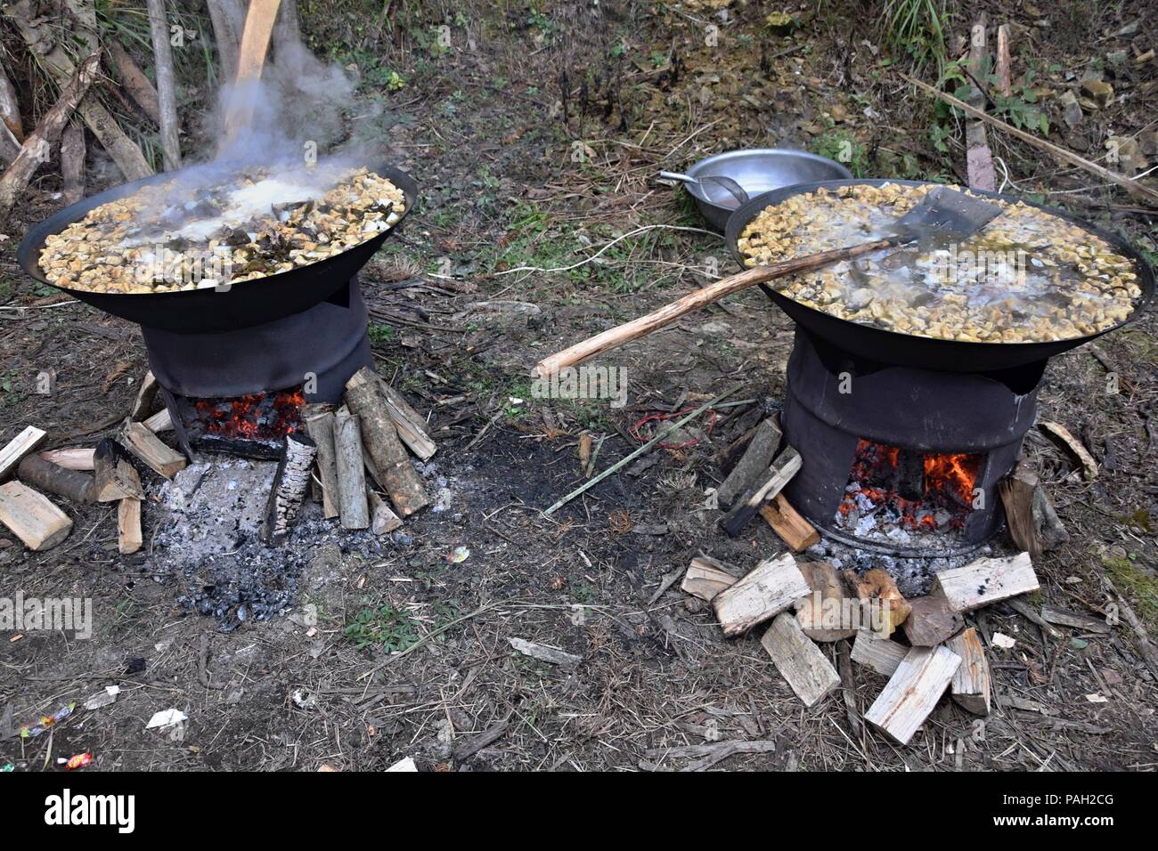 Cooking in the outdoor kitchen. Two metal barrels use as a wood-burning  stove with wok pans with tofu goulash Stock Photo - Alamy