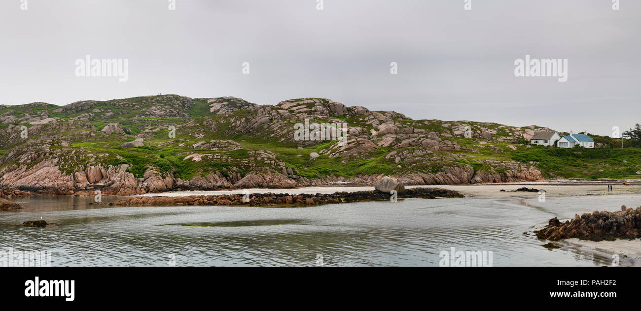 Panorama of shoreline of isolated Fionnphort fishing village on Isle of Mull Scotland with red granite rock and cracked erratic boulder Stock Photo