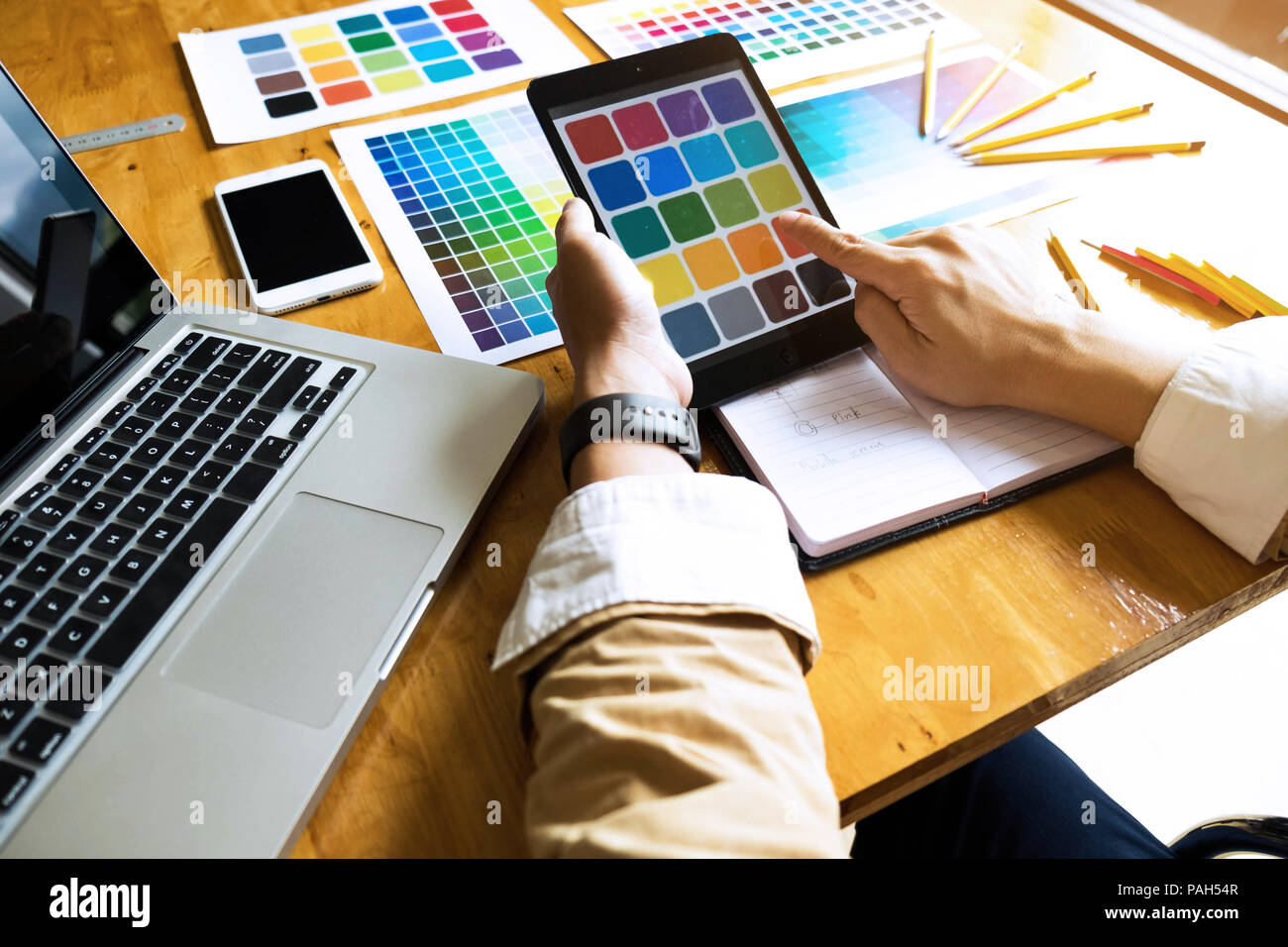Graphic designers use the tablet to choose colors from the color bar example for design ideas, Creative designs of graphic designers concept. Stock Photo