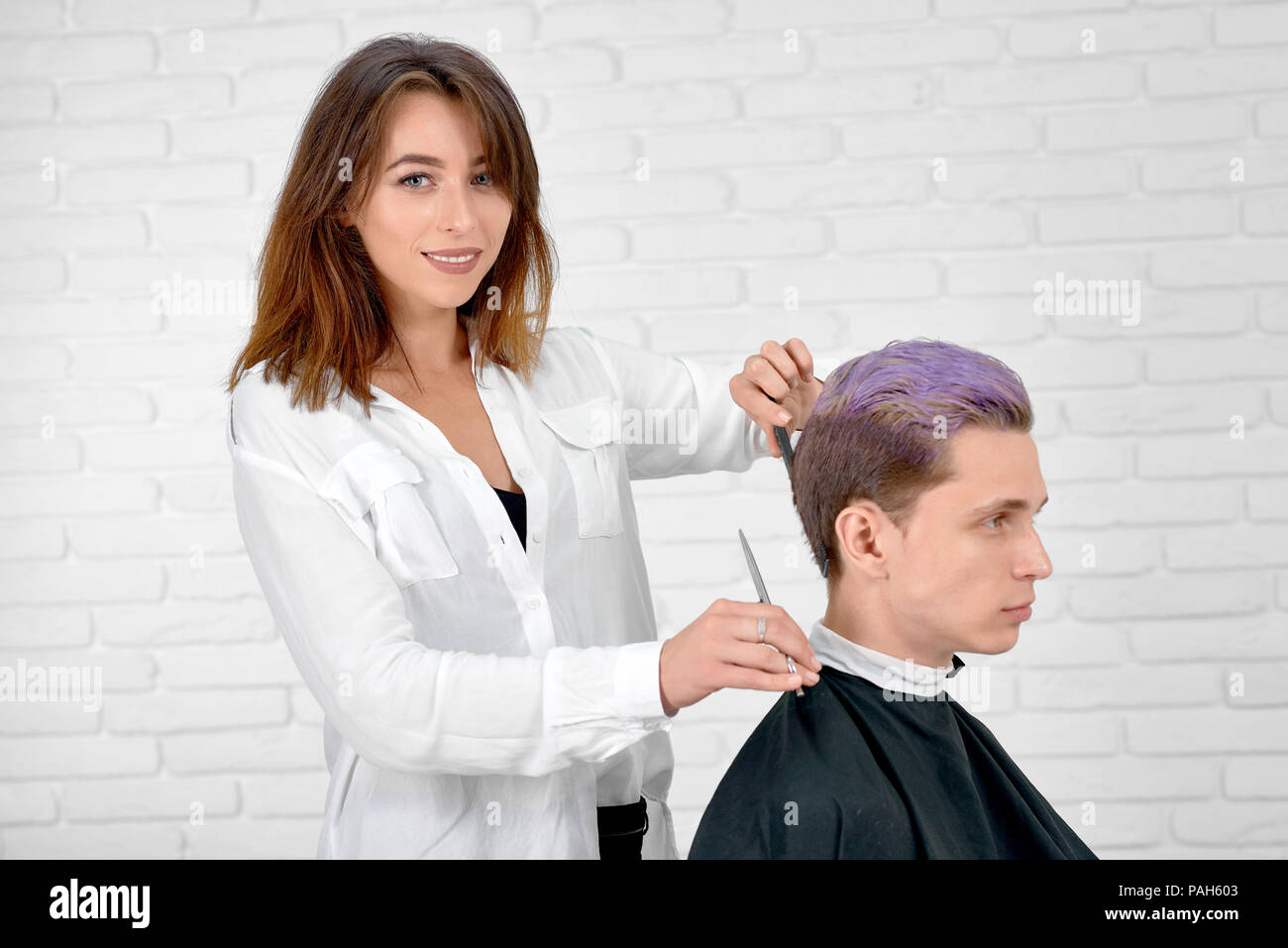 Female Hairstylist Doing Haircut For Young Client With Toned In