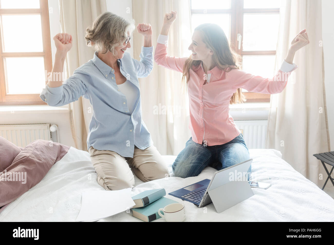 Mother and daughter working together giving high-five Stock Photo