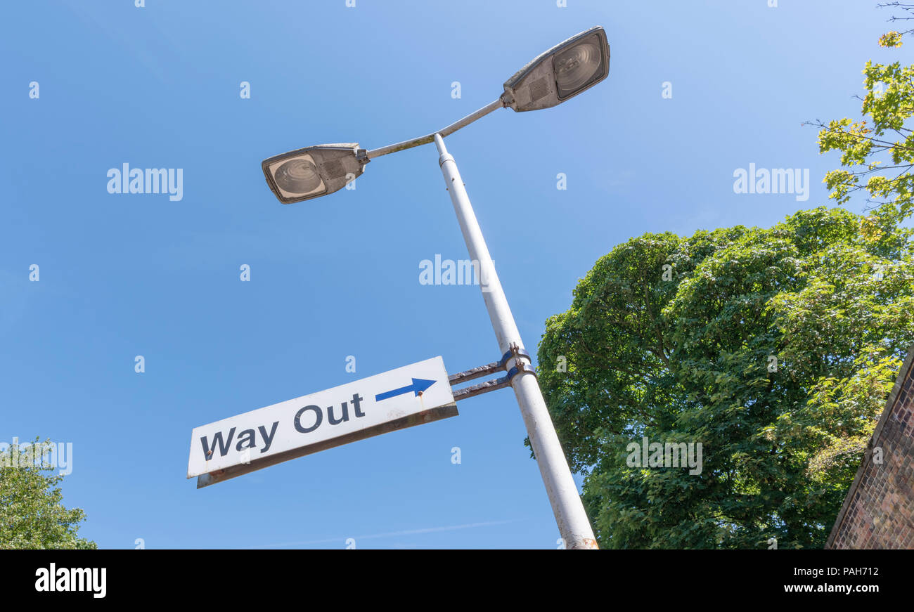 A Way Out sign attached to a lamppost at Lytham Railway Station, Lancashire, UK photographed against a blue sky Stock Photo