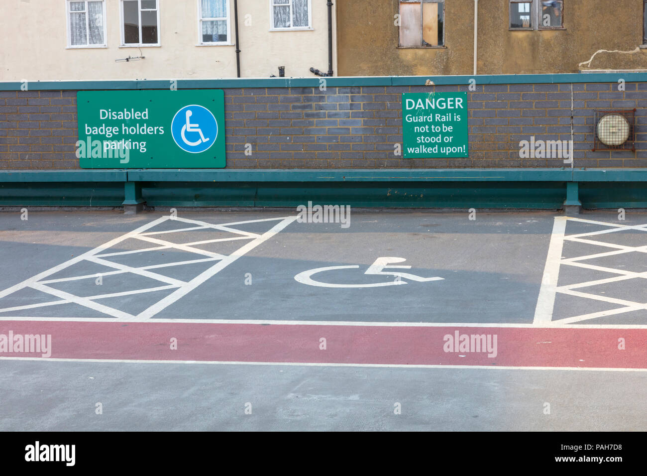 Rooftop car park disabled parking signs and warnings not to stand on a guard rail, on a Morrisons store in Herne Bay, Kent, UK Stock Photo