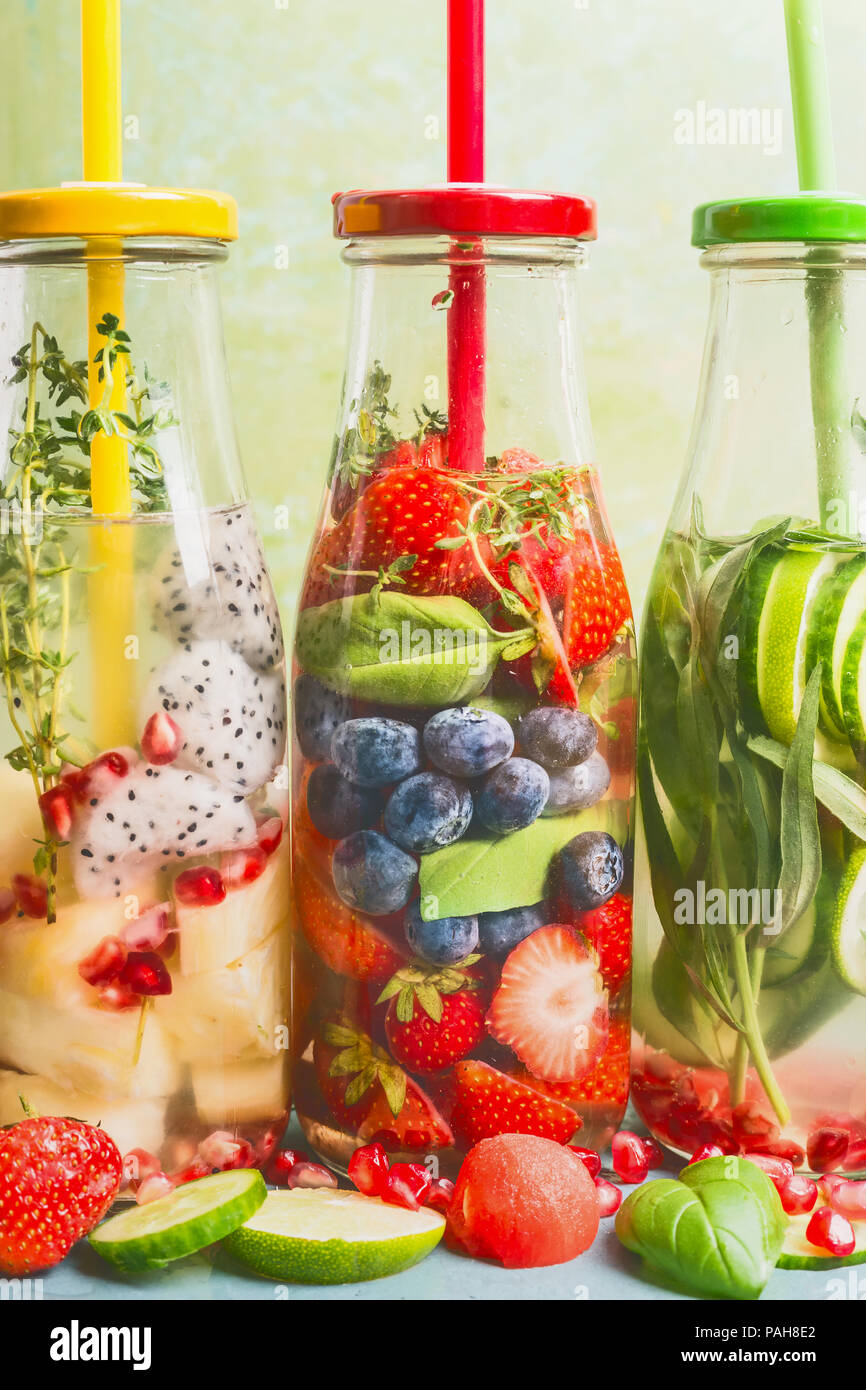 Close up of infused water in bottles with drink straw and ingredients