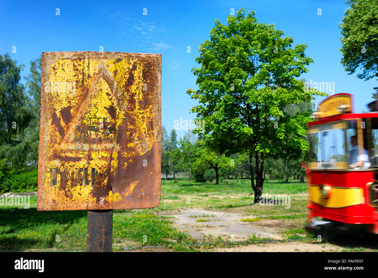 Vintage yellow rusty warning sign about a dangerous retro tram on the ...