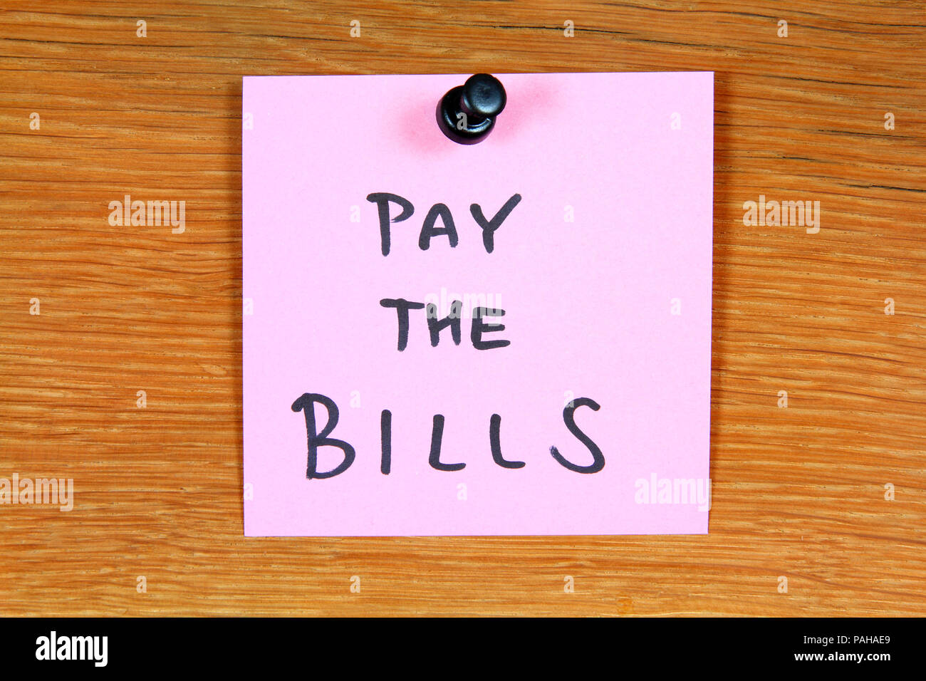 Sticky note with home expenses message pay the bills. Bulletin board Stock Photo Alamy