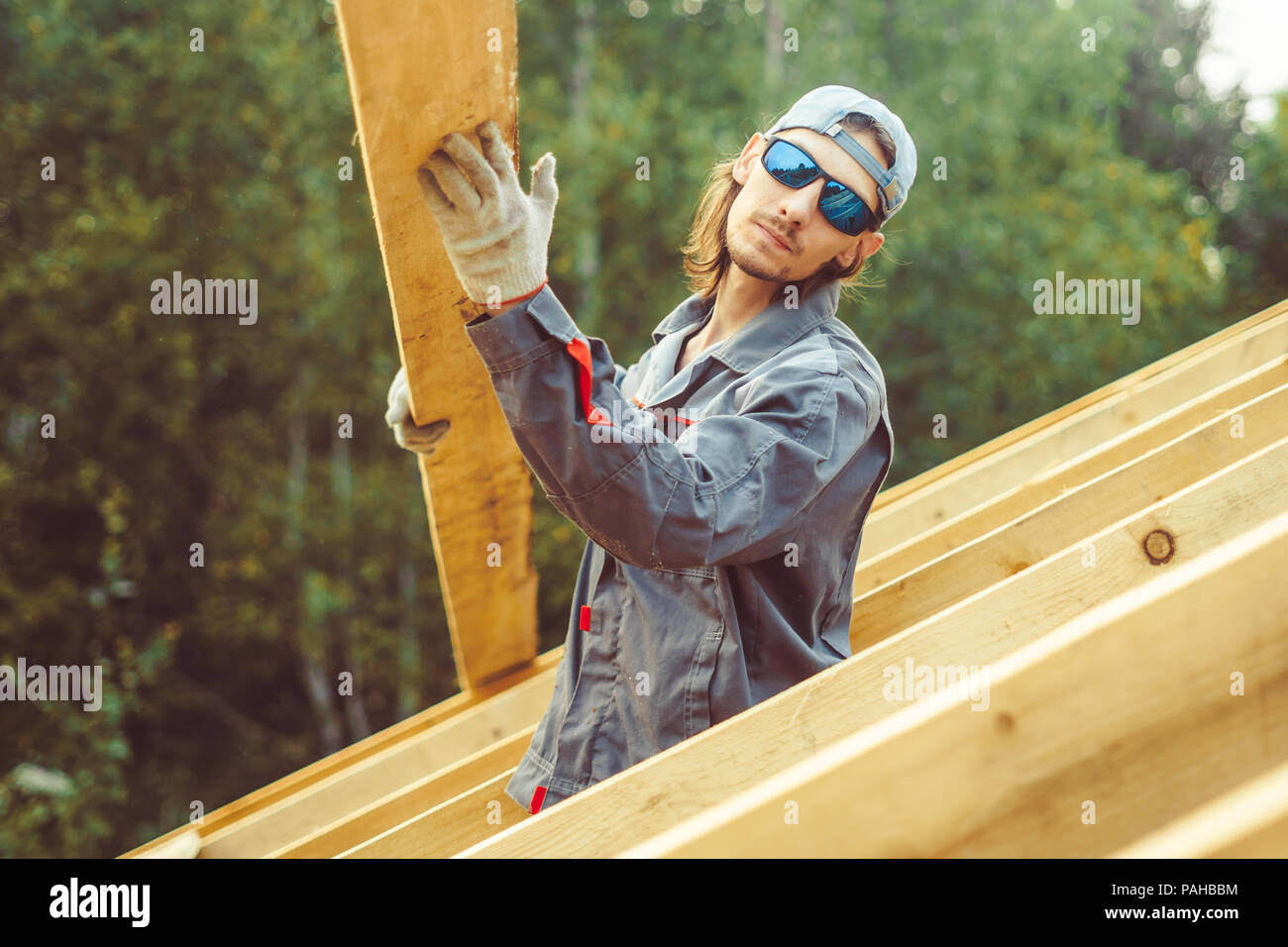 worker roofer builder working on roof structure on construction site