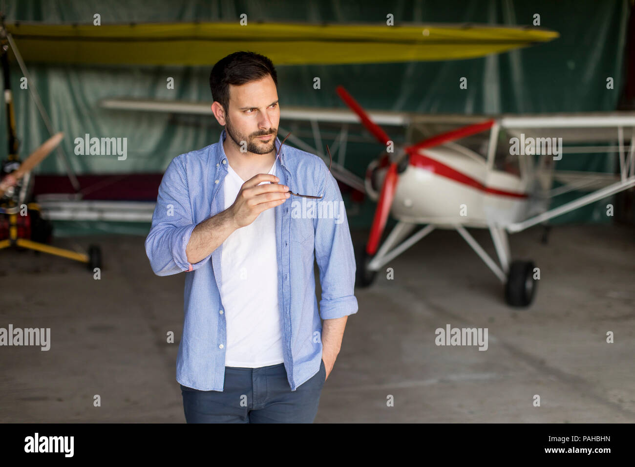 Handsome young pilot checking ultralight airplane before flight Stock Photo
