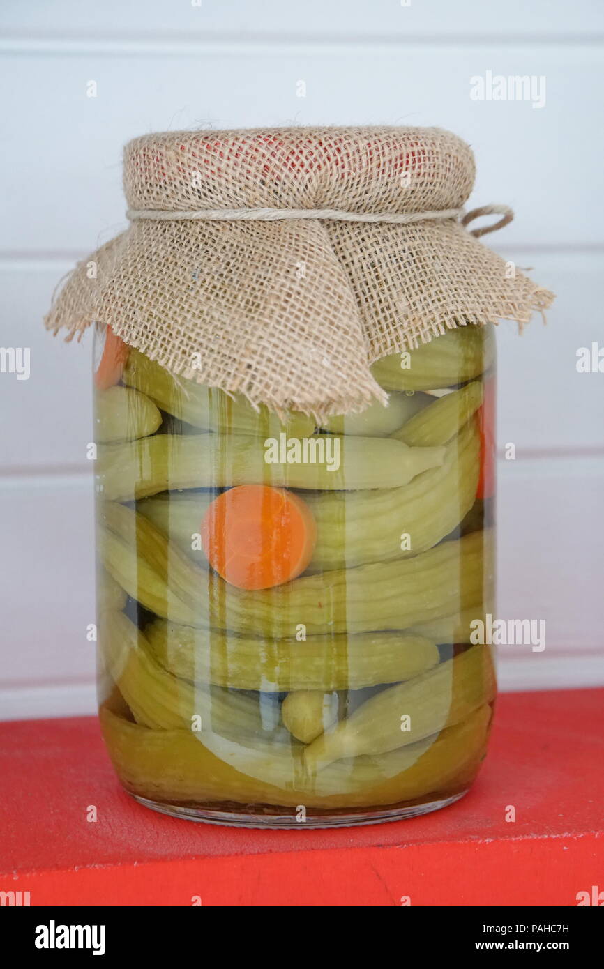 Canned cucumbers with spices in glass jar. Glass jar with pickled