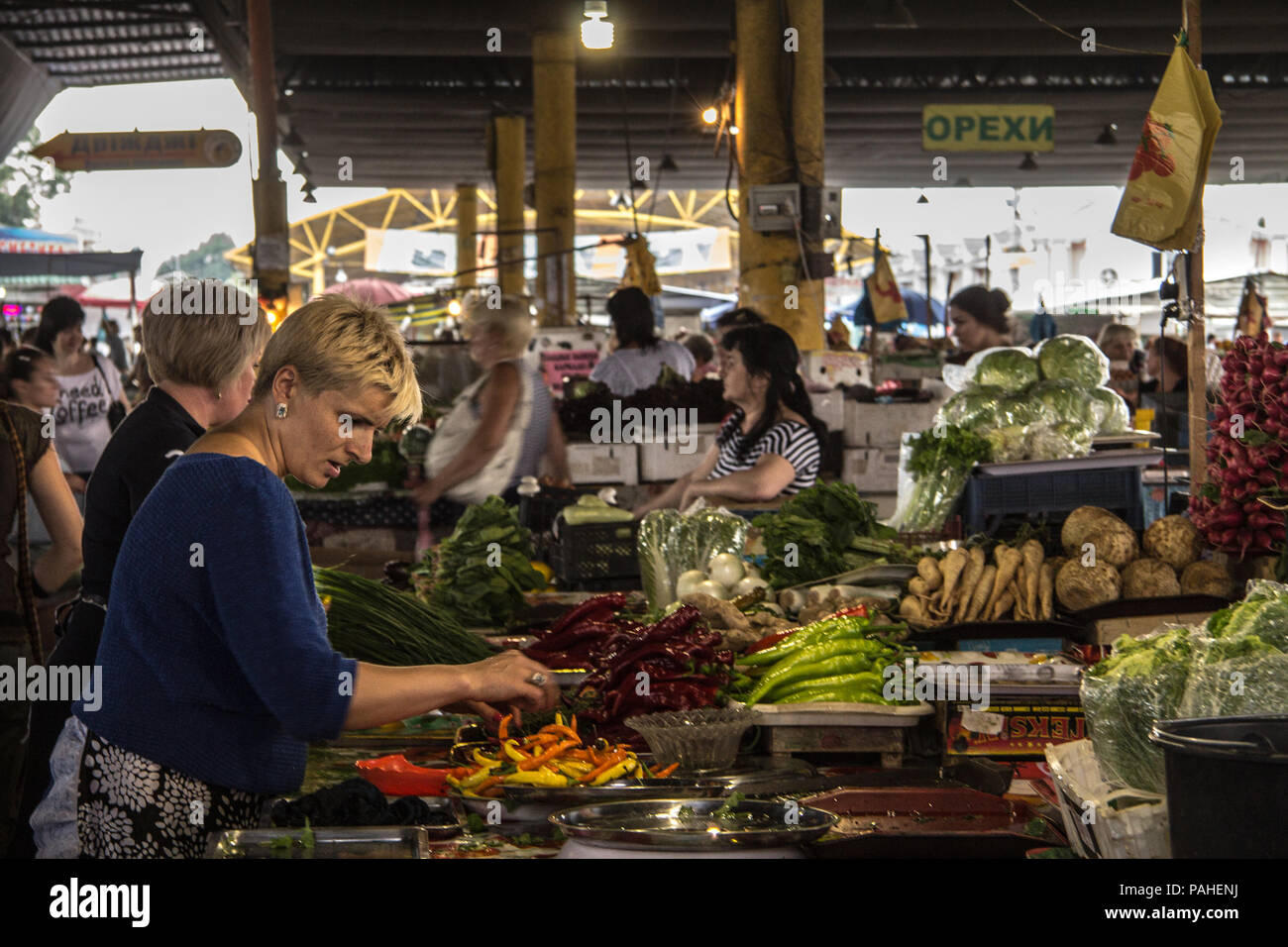 ODESSA, UKRAINE - AUGUST 13, 2015: Old woman selling fruits and vegetables, mainly peppers on Privoz Market, Odessa, Ukraine  picture of old women sel Stock Photo