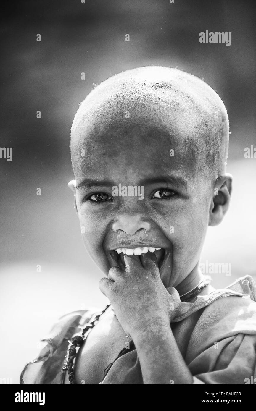 AKSUM, ETHIOPIA - SEP 24, 2011: Unidentified Ethiopian little girl in bright national dress in Ethiopia, Sep.24, 2011. Children in Ethiopia suffer of  Stock Photo