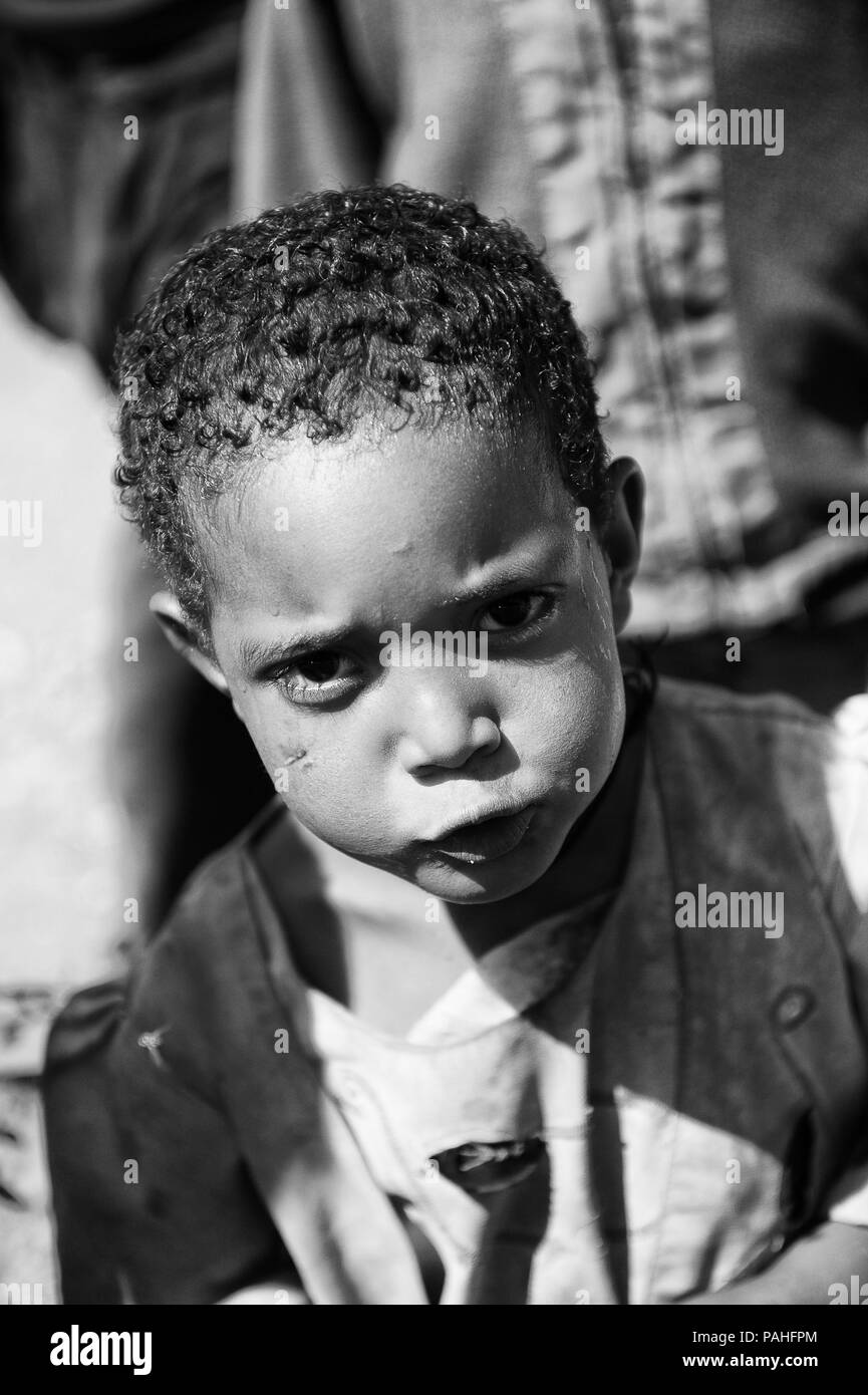 AKSUM, ETHIOPIA - SEP 28, 2011: Portrait of an unidentified Ethiopian cute little girl in old clothes in Ethiopia, Sep.28, 2011. People in Ethiopia su Stock Photo