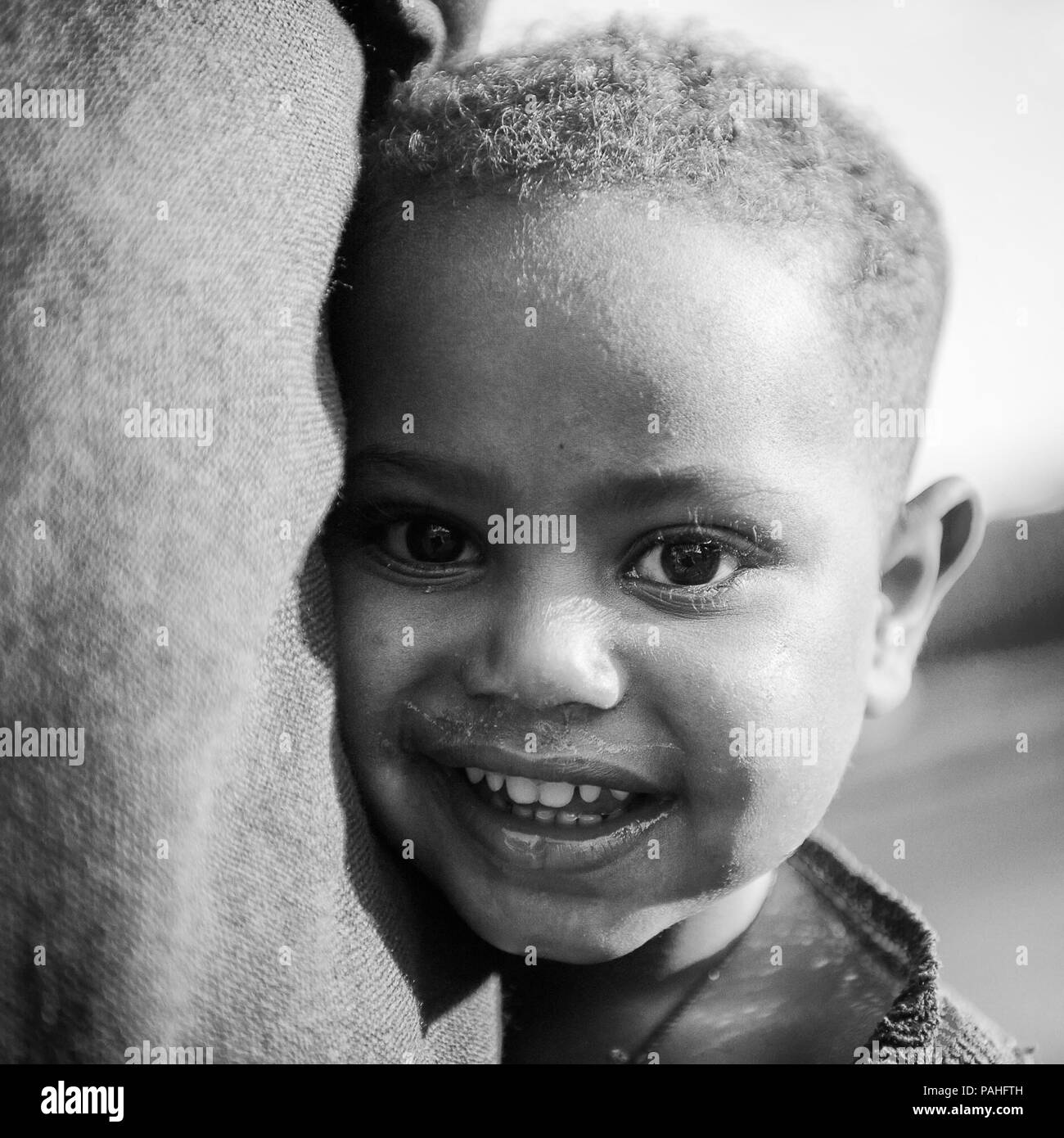 AKSUM, ETHIOPIA - SEP 30, 2011: Portrait of an unidentified Ethiopian little boy near his mother skirt in Ethiopia, Sep.30, 2011. Children in Ethiopia Stock Photo