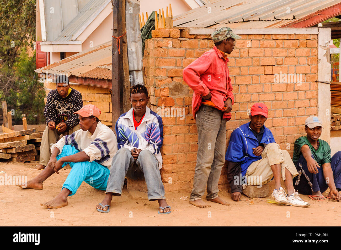 ANTANANARIVO, MADAGASCAR - JUNE 29, 2011: Unidentified Madagascar people sit in the street. People in Madagascar suffer of poverty due to the slow dev Stock Photo