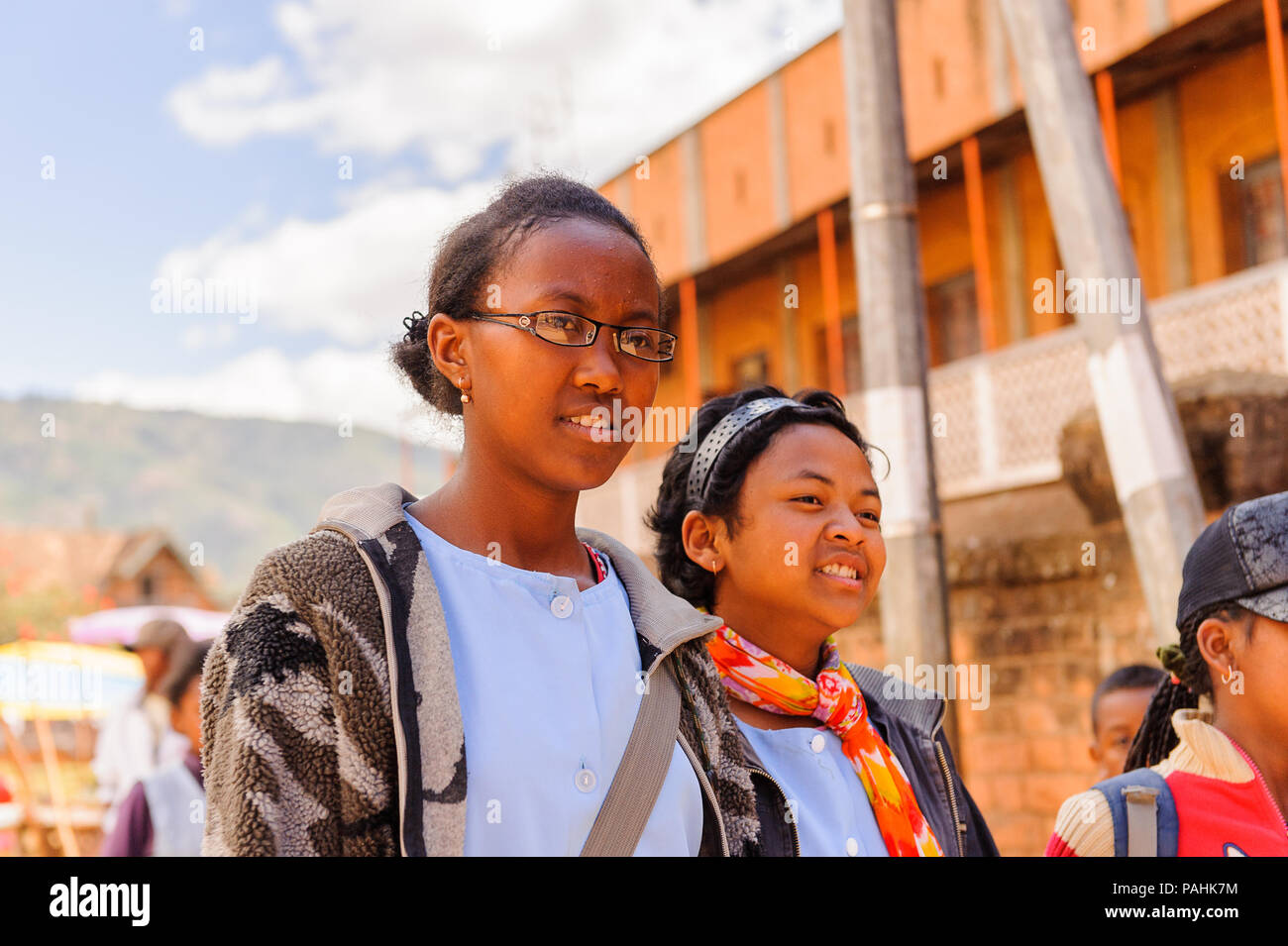 ANTANANARIVO, MADAGASCAR - JUNE 30, 2011: Unidentified Madagascar girls walk in the street. People in Madagascar suffer of poverty due to slow develop Stock Photo