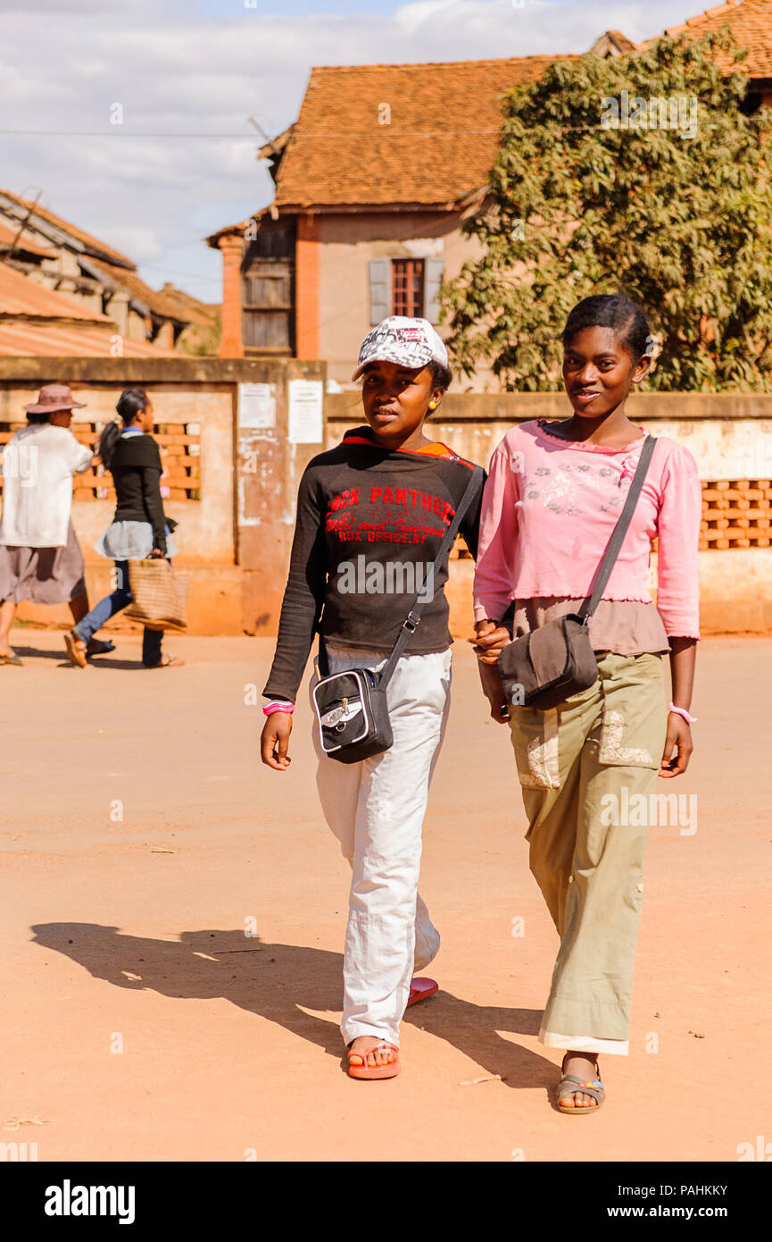 ANTANANARIVO, MADAGASCAR - JULY 1, 2011: Unidentified Madagascar girls walk together in the street. People in Madagascar suffer of poverty due to slow Stock Photo