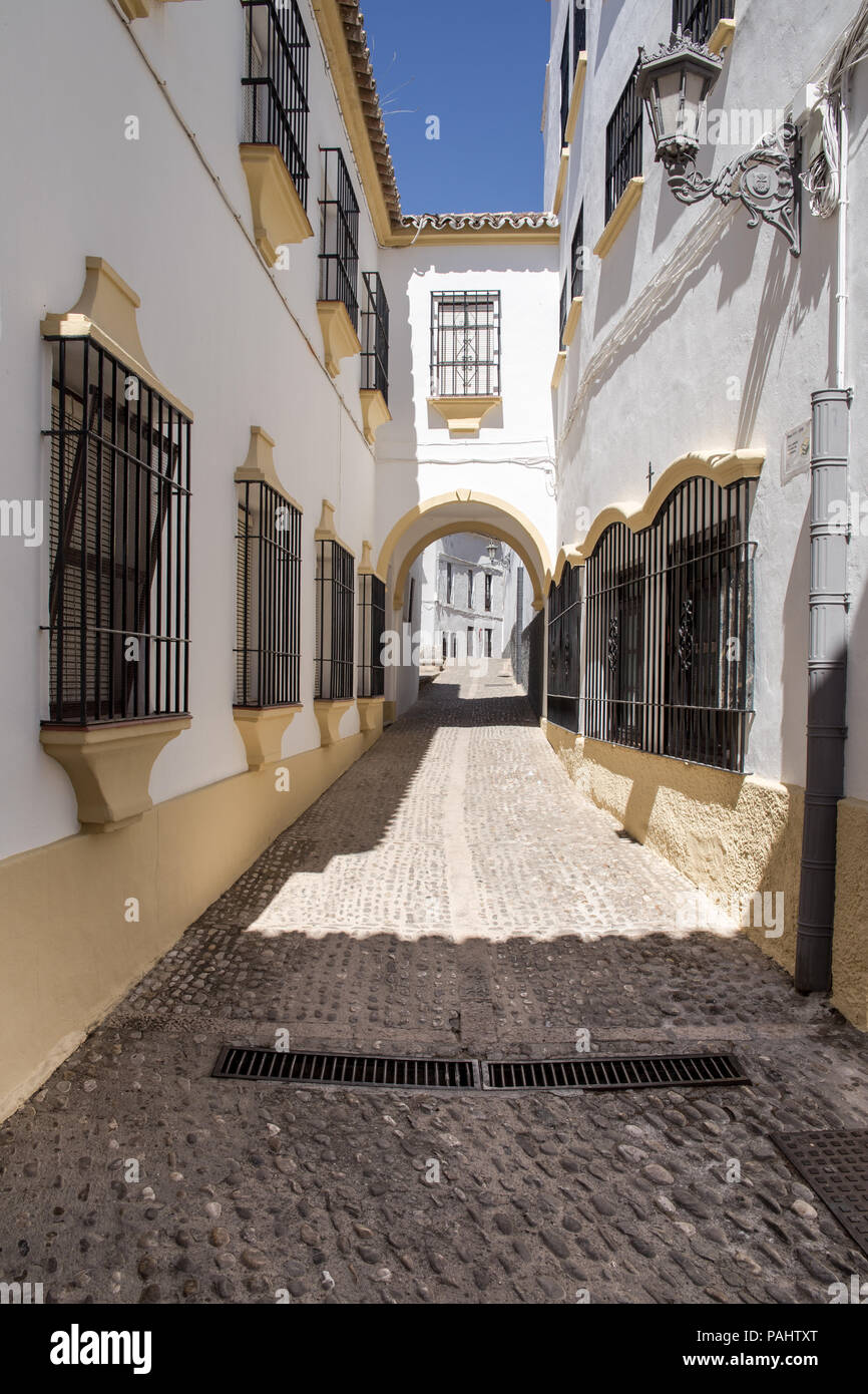 Narrow street with white facades of houses in historic district of