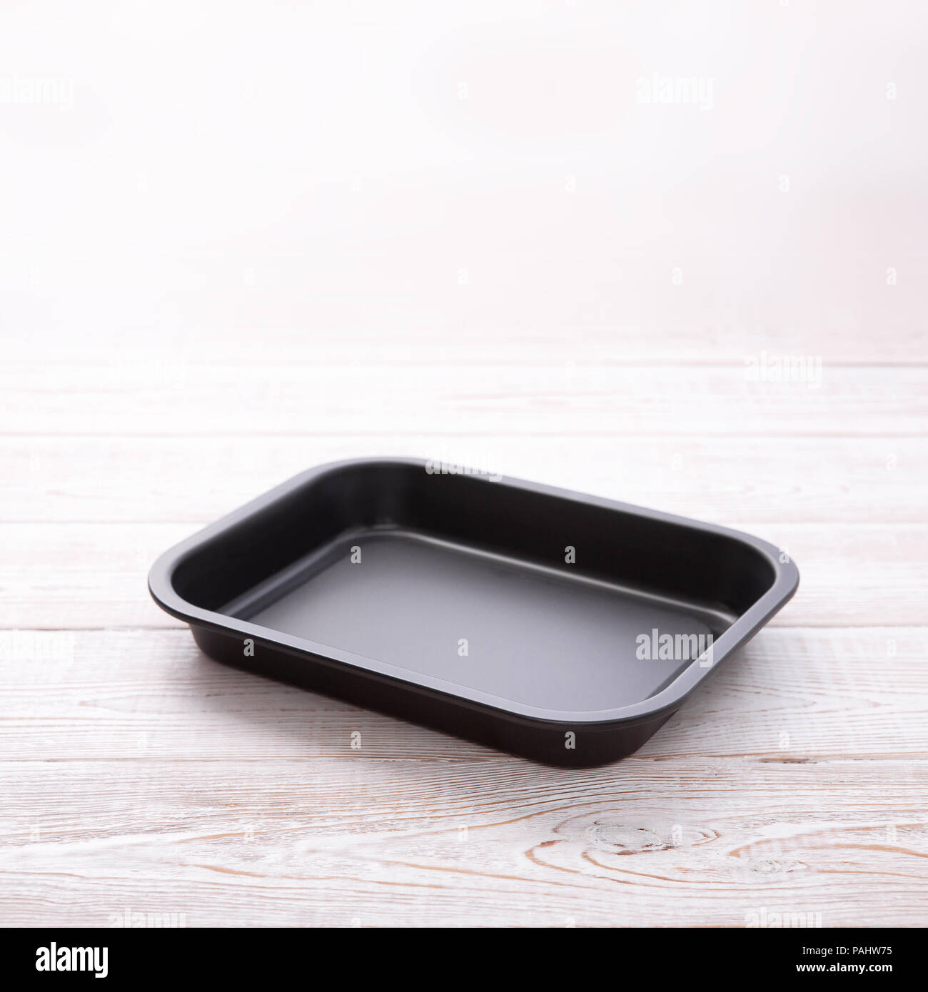 Empty baking tray for pizza close up on white wooden background top view square. Mock up for design Stock Photo