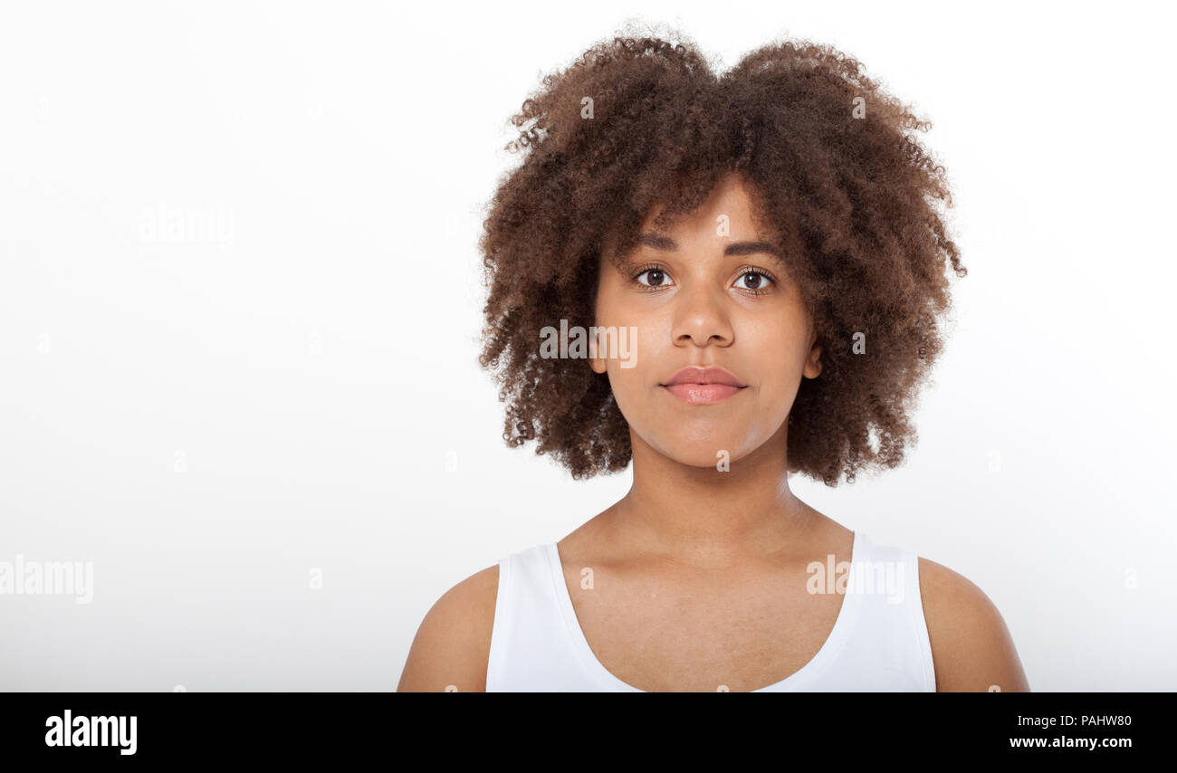 Portrait of beautiful black woman isolated. Atractive brunette dark-skinned woman in a white tank top. Stock Photo