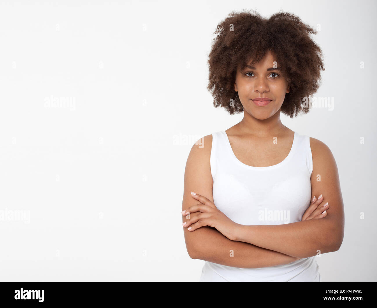 Portrait of beautiful black woman isolated. Atractive brunette dark-skinned woman in a white tank top. Stock Photo