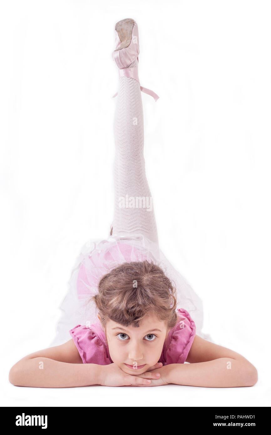 Cute, little and beautiful young ballerina girl dancing on white background. Studio shoot Stock Photo