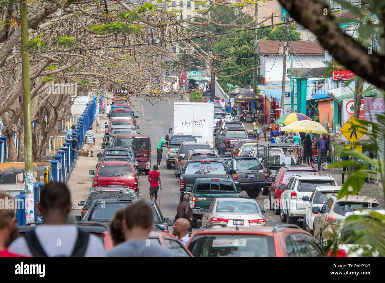 Cars drive down a crowded street in the bustling city of Monrovia