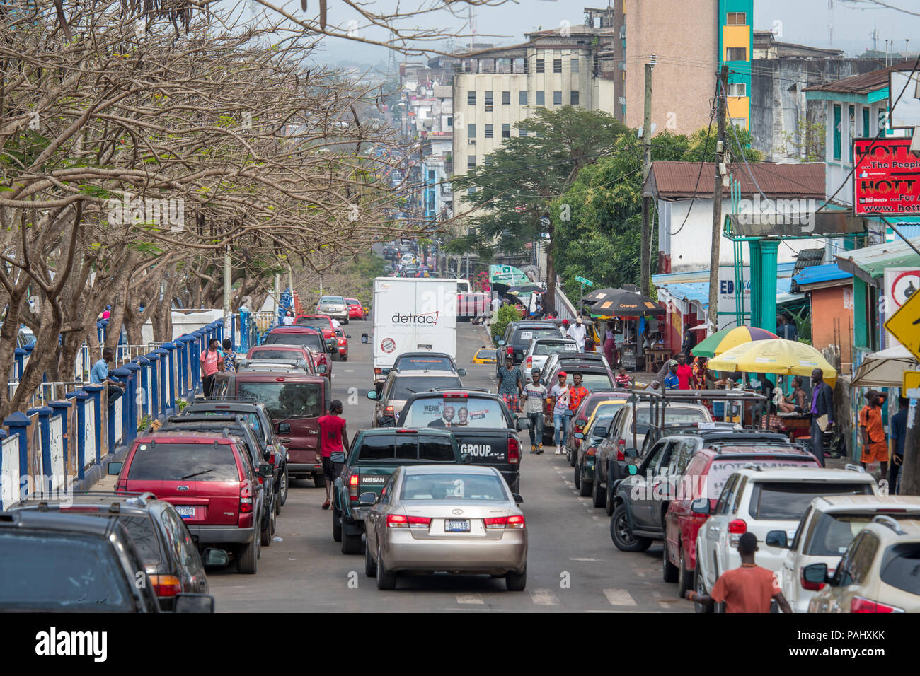 Cars drive down a crowded street in the bustling city of Monrovia